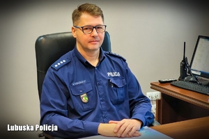 umundurowany policjant siedzi przy biurku