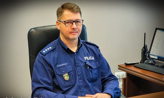 umundurowany policjant siedzi przy biurku