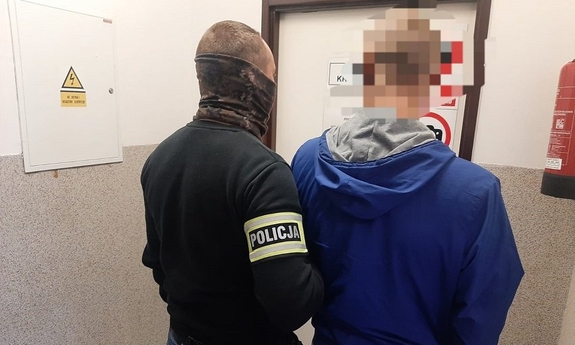 policjant prowadzi zatrzymanego mężczyznę