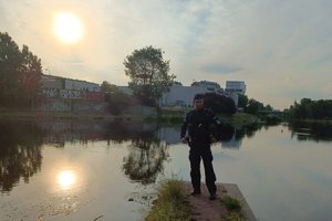 umundurowany policjant stoi nad brzegiem rzeki