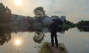 umundurowany policjant stoi nad brzegiem rzeki