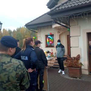 uczniowie i policjanci składają życzenia urodzinowe chłopcu