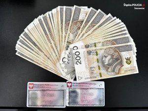 rozłożony na stole wachlarz z banknotów 200-złotowych i dowody osobiste