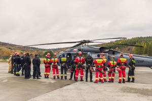 Odprawa przedstawicieli służb ratowniczych przed policyjnym śmigłowcem Black Hawk.