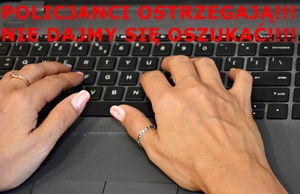 Kobiece ręce na klawiaturze, nad nimi czerwony napis Policjanci ostrzegają!!! Nie daj się oszukać!!!