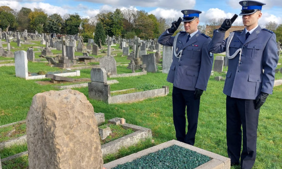 Dwaj policjanci oddają honory przed grobowcem.