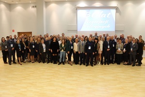 Zdjęcie zbiorowe uczestników konferencji. Za nimi widoczny napis na ekranie: 30 lat negocjacji policyjnych