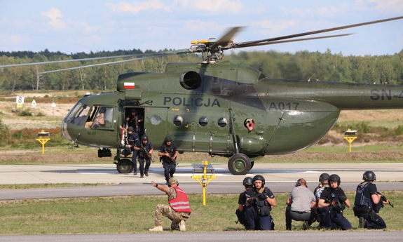 policjanci po kolei wychodzą z policyjnego śmigłowca na płytę lotniska