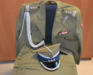 zabezpieczony przez policjantów mundur galowy pułkownika Wojska Polskiego wraz z czapką położony na krześle