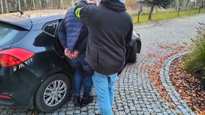 Mężczyzna wsiadający do samochodu, obok policjant