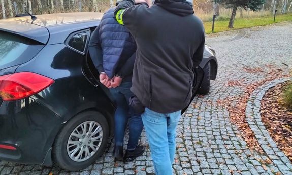 Mężczyzna wsiadający do samochodu, obok policjant