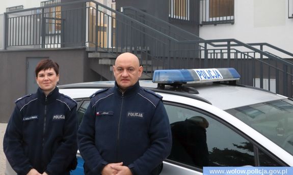 umundurowana policjantka i policjant stoją przy radiowozie