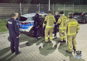 Zdjęcia przedstawiają policjantów i strażaków oraz zaginionego mężczyznę przy radiowozie