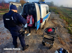 Policjant z kobietą przy radiowozie