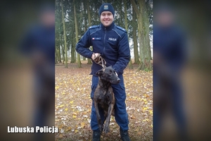 policjant trzyma na smyczy nowego psa służbowego