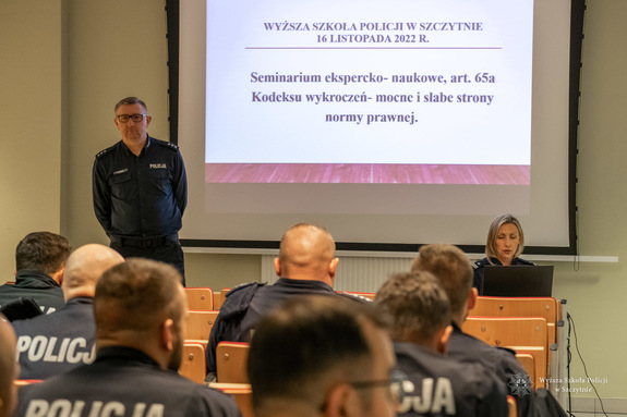 wykładowca stoi przed słuchającymi go słuchaczami - policjantami