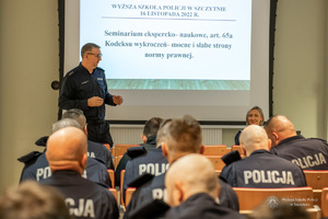 wykładowca stoi przed słuchającymi go słuchaczami - policjantami