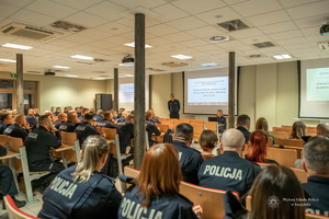 wykładowca stoi przed słuchającymi go słuchaczami - policjantami