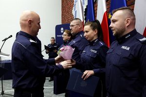 generał Policji wręcza kwiatki stojącej przed nim policjantce