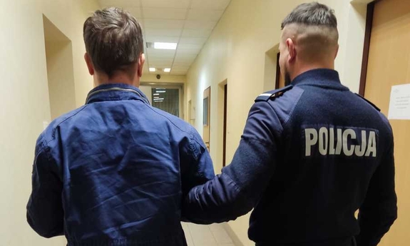 umundurowany policjant prowadzi zatrzymanego mężczyznę