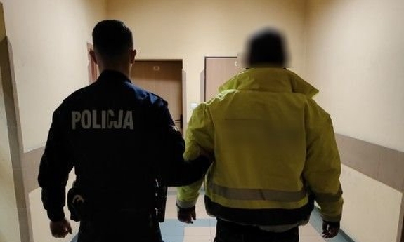 policjant prowadzi zatrzymanego mężczyznę