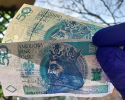 trzymane w dłoni fałszywe banknoty