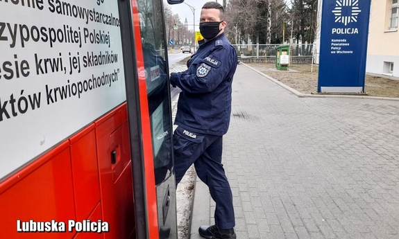 Policjant wchodzi do krwiobusa