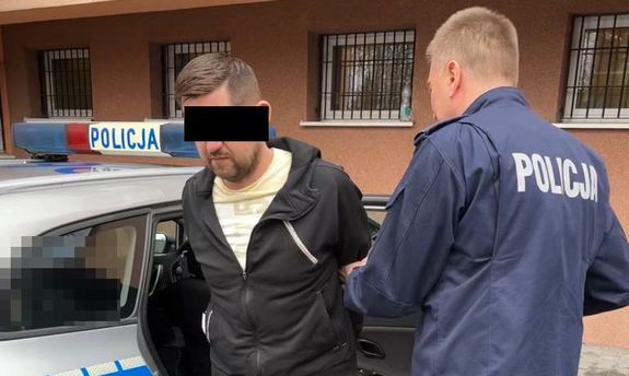 policjant prowadzi zatrzymanego