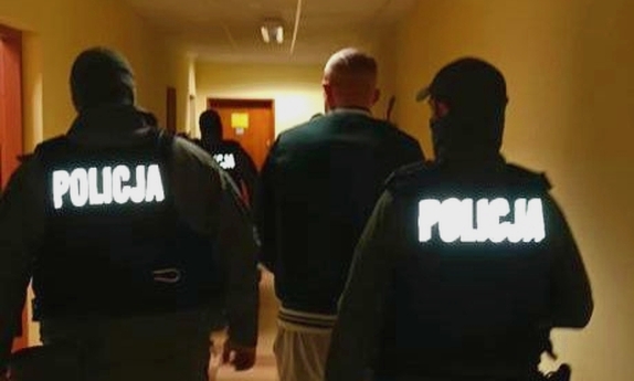 dwaj policjanci prowadzą zatrzymanego mężczyznę
