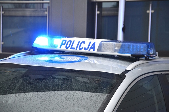 fragment policyjnego radiowozu z widoczna podświetloną belką i napisem Policja