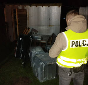policjant pracujący na miejscu włamania do budynku