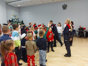 Spotkanie ze Świętym Mikołajem w Komendzie Głównej Policji - policjanci rozmawiają z grupa dzieci