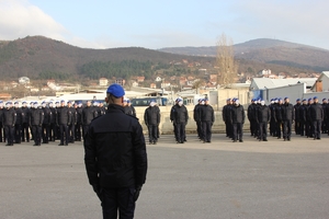 Policjanci stoją na baczność na placu w kilku szeregach