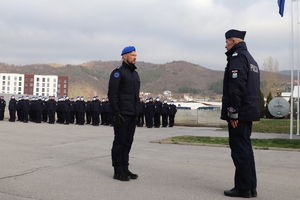 policjant stoi na baczność naprzeciwko Zastępcy Komendanta Głównego Policji, w tle Policjanci stoją na baczność na placu w kilku szeregach