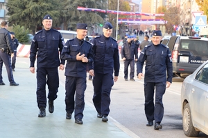 Zastępca Komendanta Głównego Policji z trzema innymi policjantami idzie ulicą, w tle policjanci