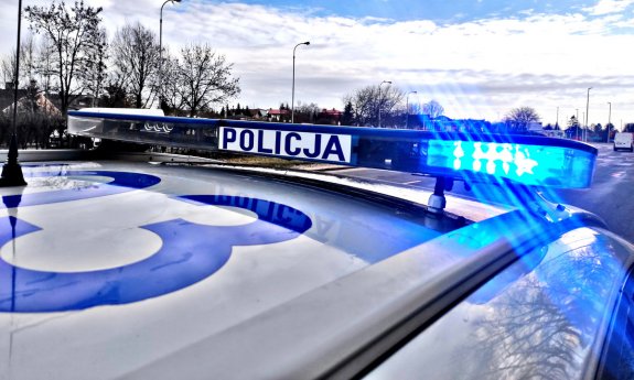 dach policyjnego radiowozu, na którym widać napis Policja znajdujący się na belce