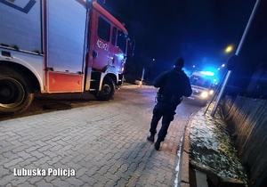 Policjant wraz z pozostałymi służbami przy ambulansie