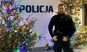 umundurowany policjant stoi przy choinkach