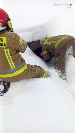 Strażacy wyciągają mężczyznę ze studzienki kanalizacyjnej