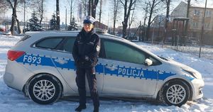 policjantka stoi przy radiowozie policyjnym