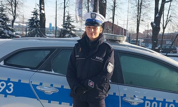 policjantka stoi przy radiowozie policyjnym