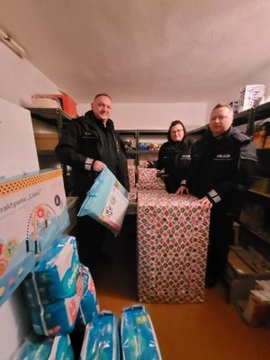 Policjanci pozują do zdjęcia z prezentami