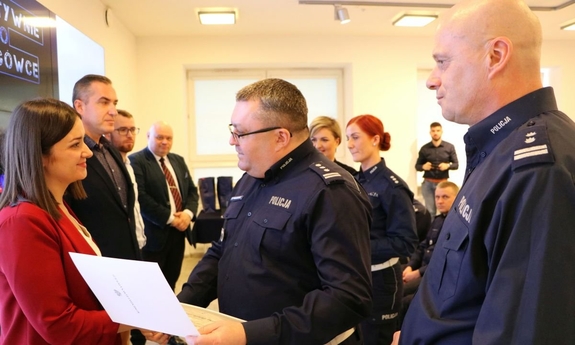 policjant wręcza zwyciężczyni nagrodę