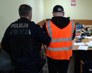 policjant z zatrzymanym mężczyzną