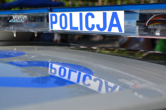 Podświetlony napis Policja na belce znajdującej się na dachu radiowozu