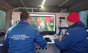 Zdjęcia przedstawiają dwóch policjantów podczas czynności poszukiwawczych przed ekranem komputera w pojeździe służbowym