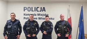 Umundurowani policjanci stojący na korytarzu