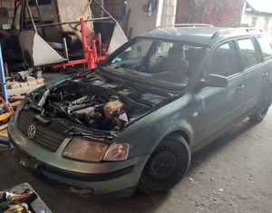 Częściowo zdemontowany samochód stojący w garażu