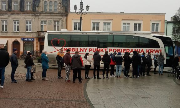 ludzie  ustawieni w  kolejkę przed autobusem