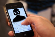 Dłoń trzymająca smartfon wyświetlający sylwetkę przestępcy na ekranie